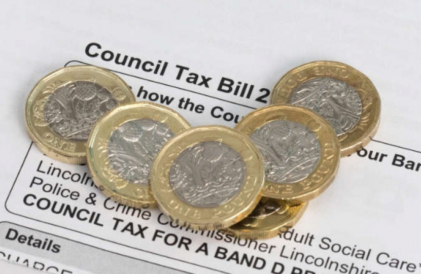 Council Tax Bill with pound coins on top of it