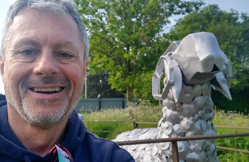 Cllr Tim Nelson standing next to a metal sheep