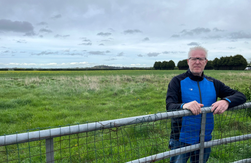 Phil Loughlin standing behind a gate overlooking the fields next to Station Road in The Humbers