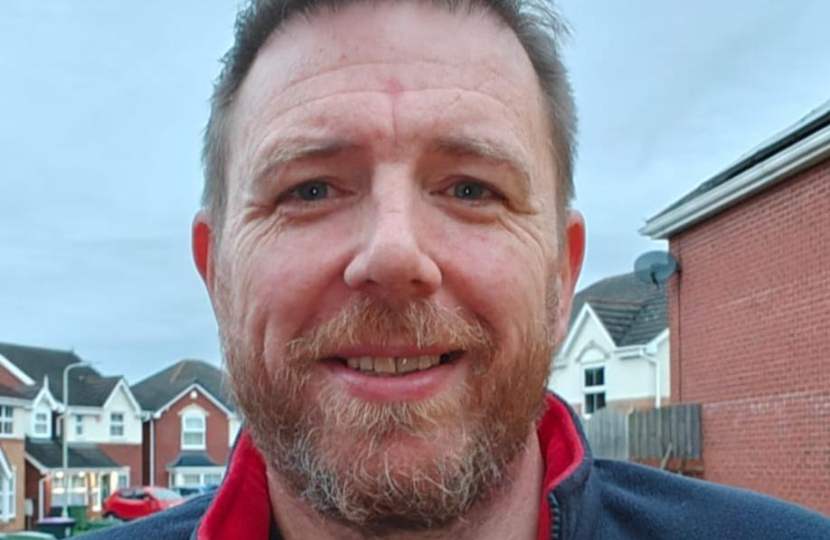 Stuart Parr head and shoulders with blue sky and houses in the background