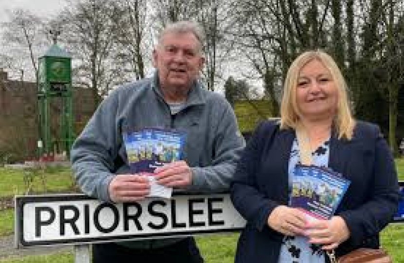 Cllrs Paul Thomas and Rachael Tyrell leaning on a Priorslee road sign