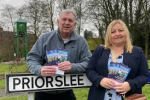 Cllrs Paul Thomas and Rachael Tyrell leaning on a Priorslee road sign